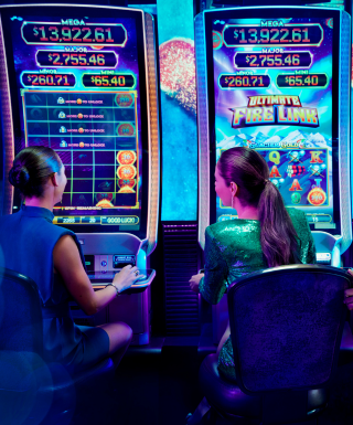 man and woman smiling playing a slot machine